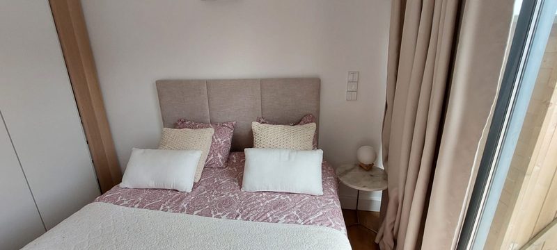 Room B with a double bed, an upholstered headboard and a floor-to-ceiling window